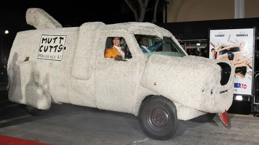 a behind-the-scenes photo of jim carrey and jeff daniels with the mutt cutts van.