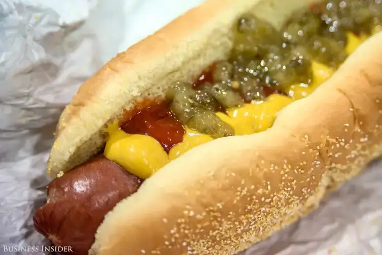 a costco hot dog in a bun with condiments.