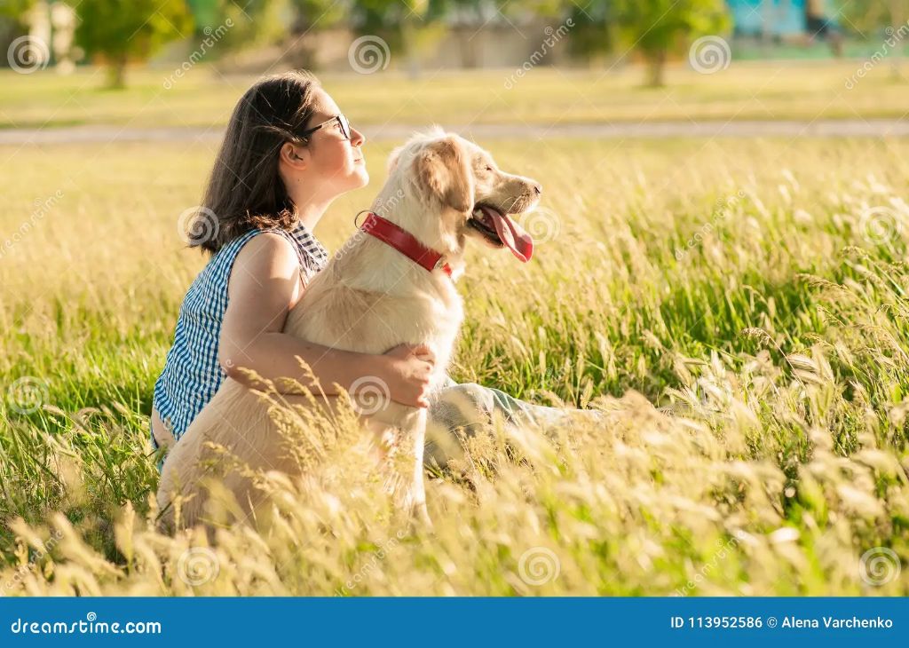 a dog and owner sitting together outdoors enjoying nature