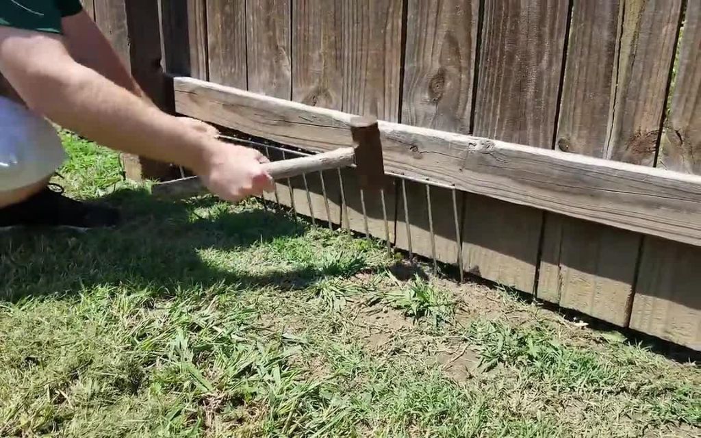 a homeowner installing secure fencing dug into the ground to prevent foxes from digging underneath.