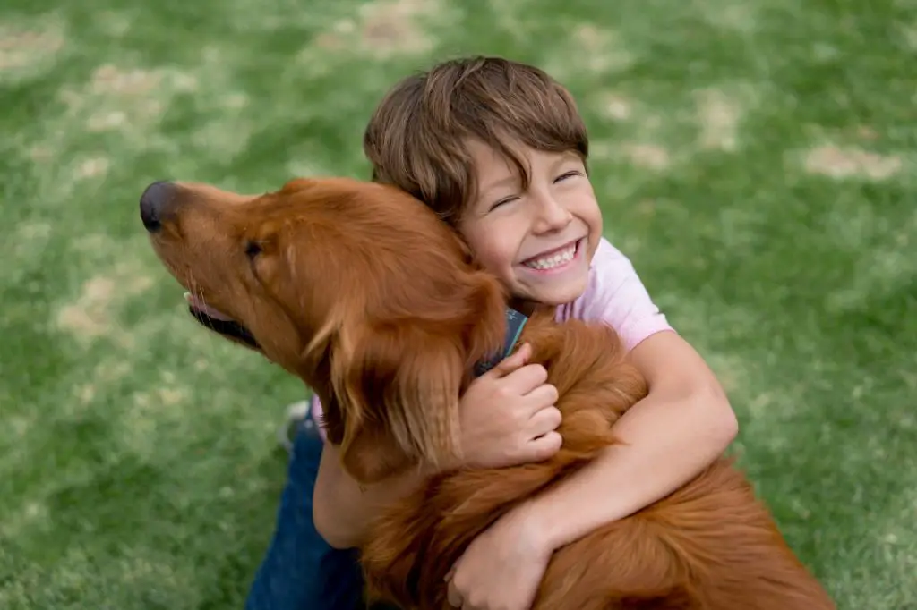 a person hugging their dog goodbye