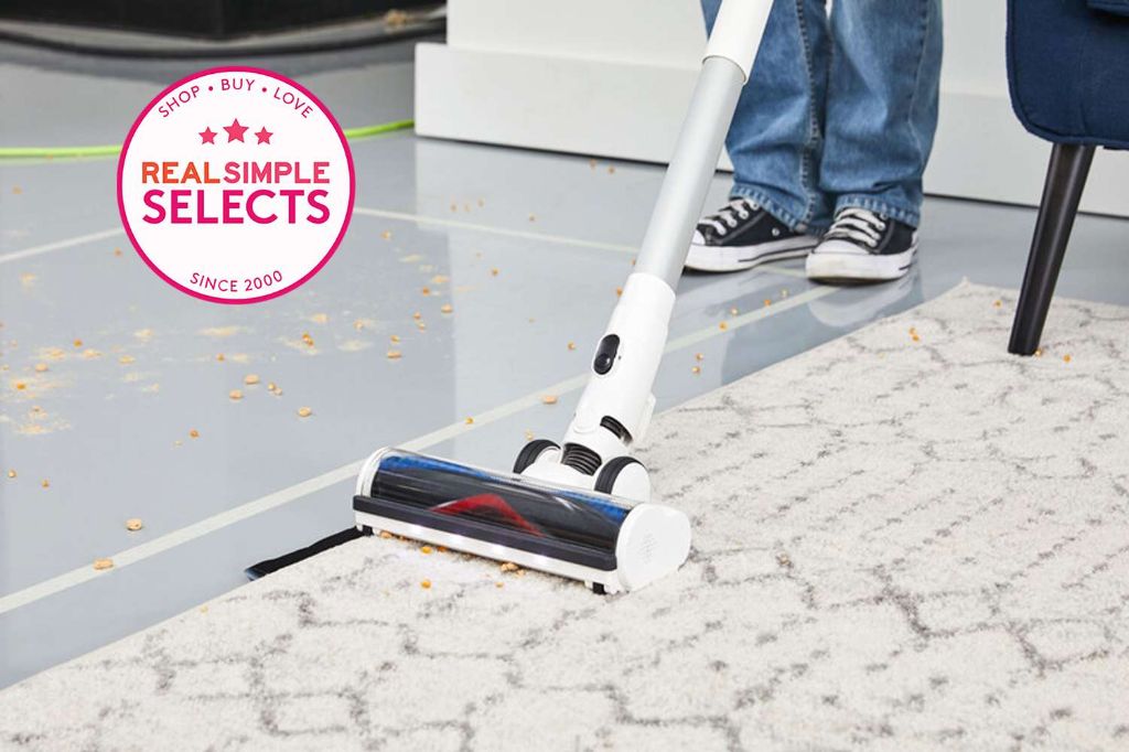 a person vacuuming luxury vinyl plank flooring to pick up pet hair.