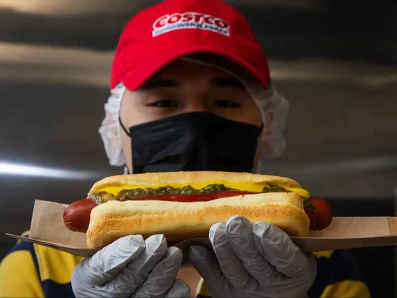 a satisfied customer enjoying a costco hot dog.