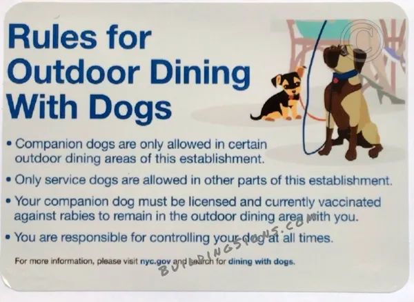 a sign displaying rules for dogs in an outdoor dining area