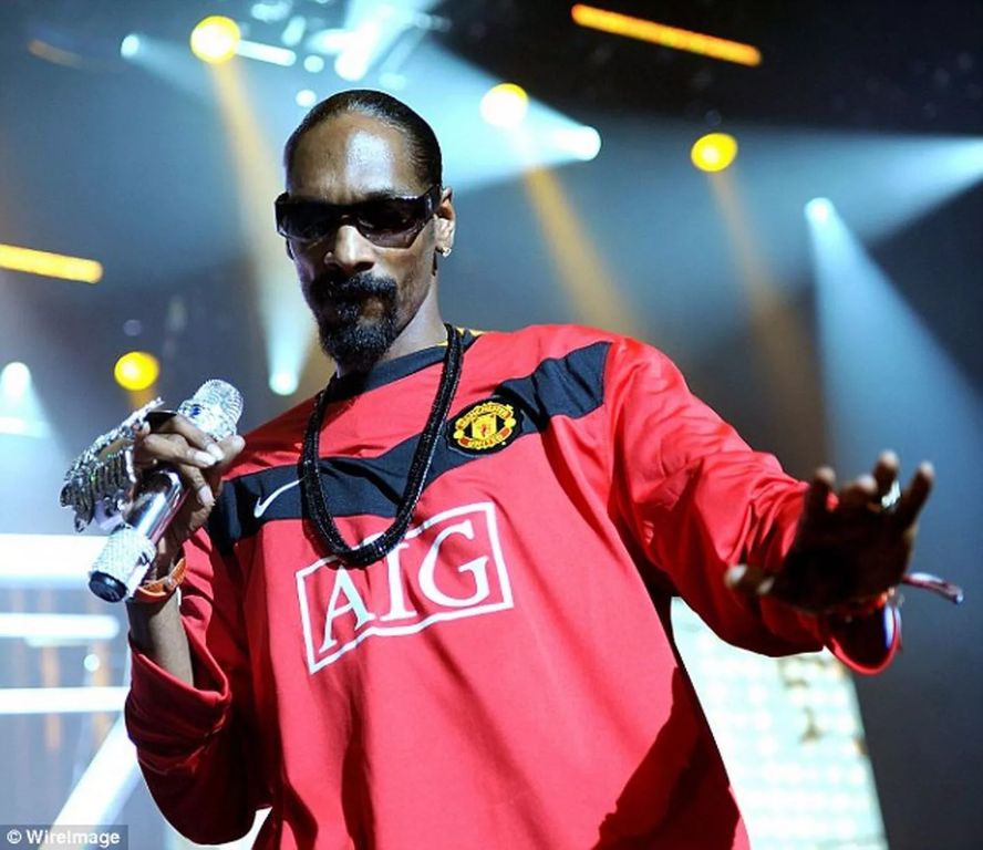 an image of snoop dogg wearing a football jersey during a concert