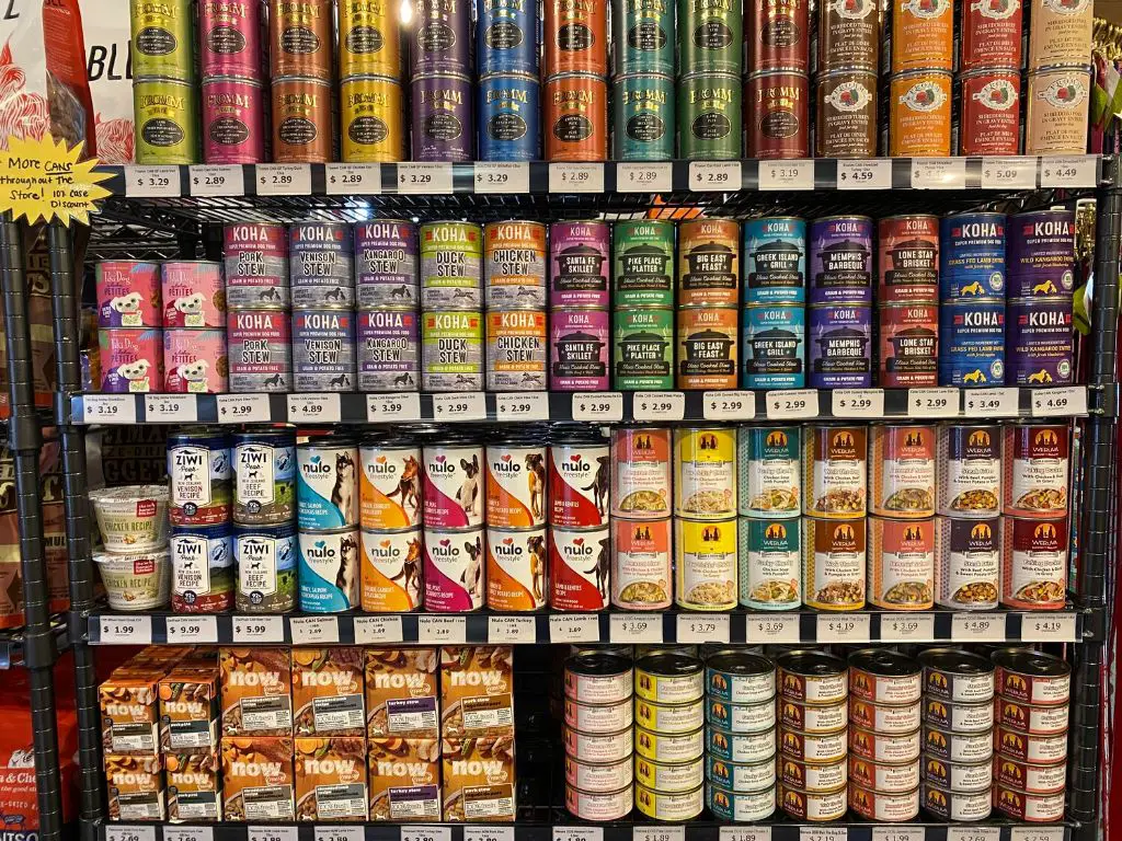 cans of dog food on a shelf in a store