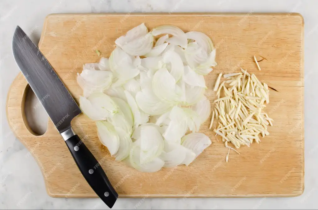 chopped onions and garlic on a cutting board