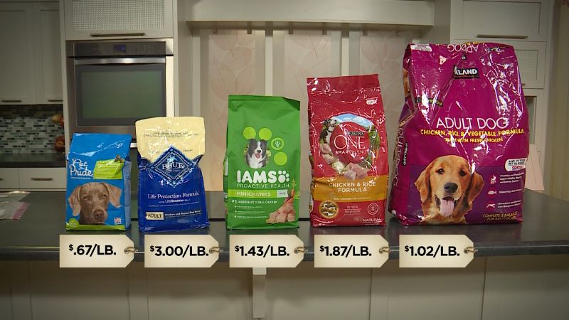 rows of different brands and varieties of dry dog food bags on display at a costco warehouse.