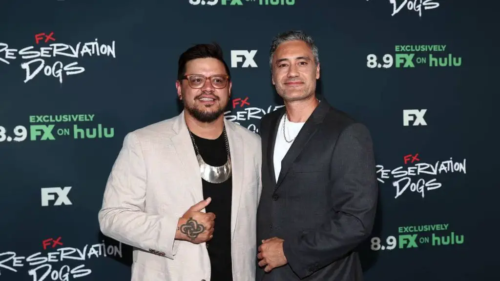 sterlin harjo and taika waititi smile at an event